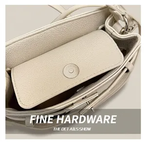 Detailed macro view of the silver magnetic closure and pebble leather on the handbag