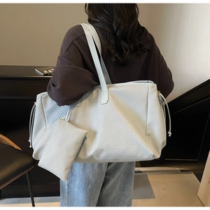 Détail de la texture tressée de ce grand sac cabas avec sa pochette assortie amovible