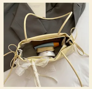 Top view of cream yellow leather underarm bag showing spacious interior with cosmetics