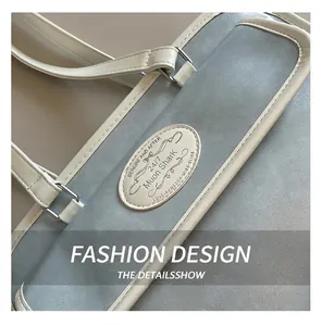 Gros plan du sac cabas bleu clair montrant le patch en cuir blanc et les coutures