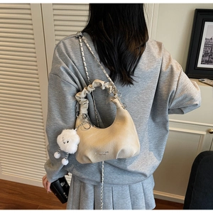 Sac à main beige avec poignée froncée et breloque peluche nuage blanc sur chaîne argentée