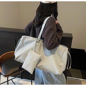 Détail du grand sac cabas tressé gris avec petite pochette zippée et bandoulière longue