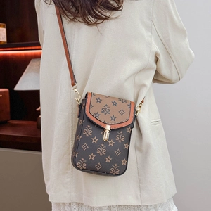 Detail of vintage crossbody phone bag featuring brown monogram pattern and gold lock