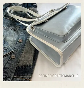 Détail du sac cabas bleu montrant les coutures et la finition des bordures blanches