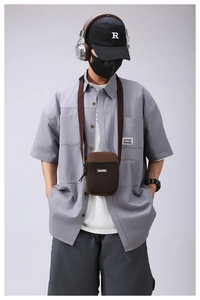Detail view of coffee brown crossbody phone bag with mesh pocket and adjustable strap