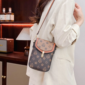 Vertical crossbody phone bag with vintage monogram and gold buckle shown on model