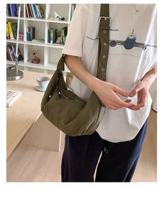 Detail view of military green nylon hobo bag showing adjustable strap and silver eyelets