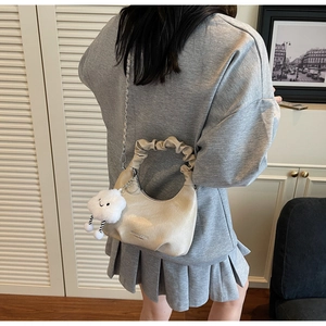 Détail du sac à main plissé doré champagne avec chaîne argentée et pendentif nuage
