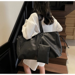 Détail du grand sac cabas en cuir tressé noir avec sa pochette intérieure assortie