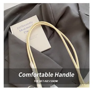 Close-up of minimalist beige shoulder bag with high-quality handle and clean stitching
