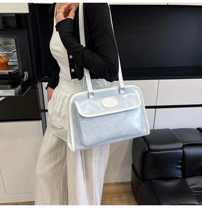 Détail du sac cabas bleu clair avec bordure blanche et poche à rabat élégante