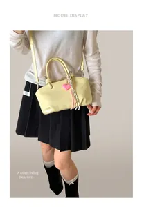 Macro view of cream bucket bag with pink heart charm and braided cord details