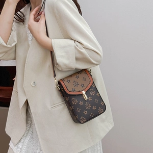 Close-up of retro monogram crossbody bag with metallic clasp and adjustable shoulder strap