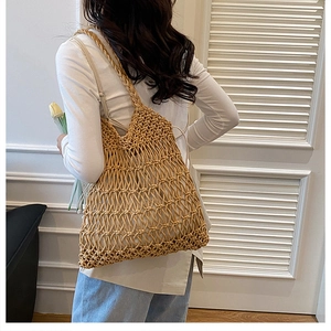 Detail of hollow woven cotton tote bag with mesh texture worn by a model for beach style