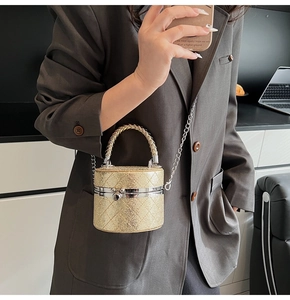 Mini-Eimer-Tasche in Champagner-Gold mit Glitzer-Finish auf einem eleganten Anzug