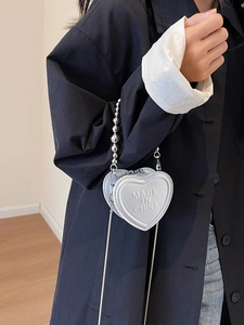 Mini silver heart-shaped crossbody bag with metal chain strap and embossed lettering