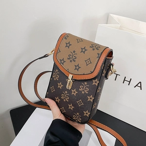 Detail of vintage brown monogram mini phone bag with golden clasp and leather trim