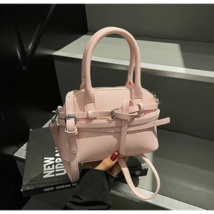 Gros plan d'un mini sac rose en cuir grainé avec boucle argentée et bandoulière fine