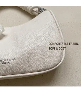Dettaglio borsa in pelle martellata bianco crema con manico intrecciato e logo stampato