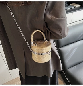 Detailansicht einer goldenen Glitzer-Zylindertasche mit Kettenriemen am Körper getragen