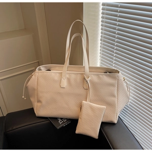 Détail du sac fourre-tout tissé crème avec pochette assortie et accents de cordon de serrage