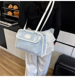 Détail du sac bandoulière en cuir PU bleu clair avec liseré blanc et poche magnétique