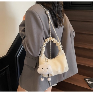 Détail du sac demi-lune crème avec poignée froncée et breloque nuage mignonne