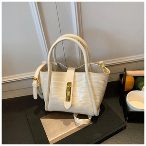 Detailed close-up of white croco pattern bucket bag with golden twist lock and shoulder strap