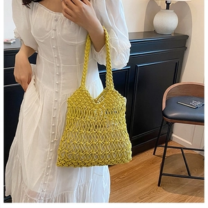Close-up of ginger yellow crochet tote bag with woven mesh pattern and drawstring pouch