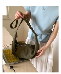Close-up of olive green nylon hobo bag showing smooth metal zipper and adjustable strap