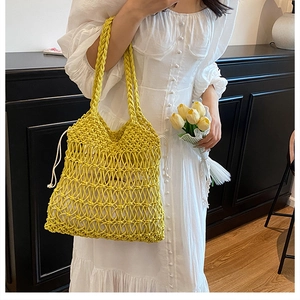 Detail of hollow woven cotton shoulder bag with beige drawstring lining and thick handles