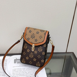 Detail of vintage brown patterned crossbody bag with metal twist lock on magazine
