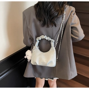 Détail du sac demi-lune vert menthe avec poignée froncée et breloque sur modèle