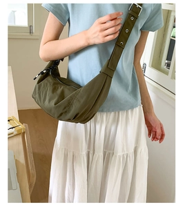 Detail of army green nylon crescent bag showing adjustable strap and texture on model