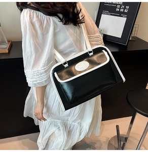 Détail d'un sac à main chic contrasté noir et blanc avec rabat porté par un mannequin
