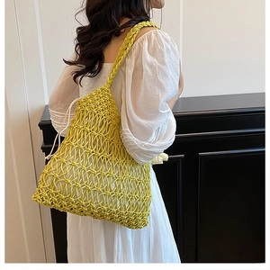 Detail of yellow woven straw beach bag with honeycombed texture and white cotton liner