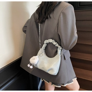 Détail du sac croissant vert menthe avec poignée froncée et breloque nuage en peluche