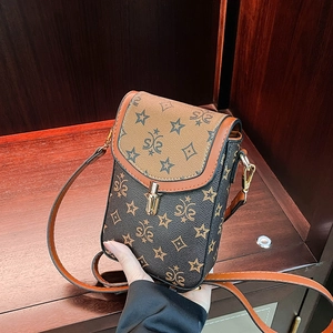 Detail of vintage patchwork mini crossbody phone bag with star patterns and gold lock