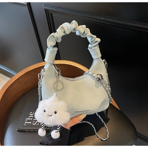 Détail du sac hobo bleu clair avec poignée froncée, chaîne et charm nuage en peluche