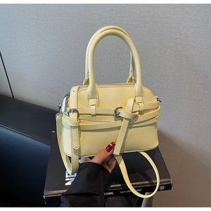 Détail du sac à main jaune pâle en cuir grainé avec bandoulière et fermoir métal