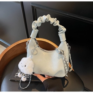 Détail du sac hobo bleu clair avec poignée plissée, chaîne argentée et charm nuage