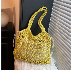 Detail of yellow hollow-out woven cotton beach bag with a white drawstring liner bag