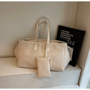Détail du sac cabas tissé avec cordon de serrage et pochette assortie sur marbre