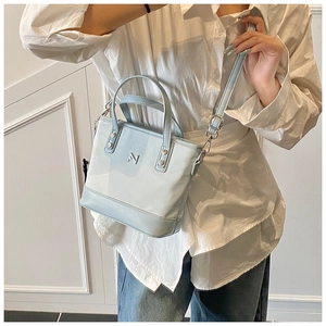 Detail of light blue faux leather bucket bag with silver hardware and adjustable strap
