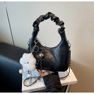 Détail d'un sac croissant plissé noir avec chaîne argentée et charme nuage en peluche