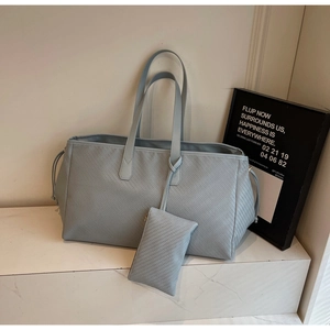 Détail d'un cabas en cuir tressé bleu clair avec sa petite pochette zippée assortie