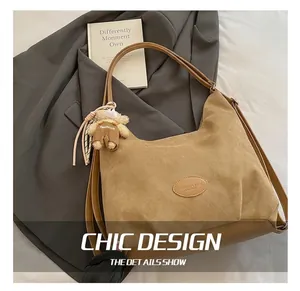 Detail of khaki suede tote bag with vintage oval logo and plush bear accessory
