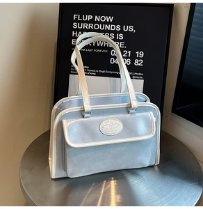 Vue détaillée d'un sac à main bleu clair vintage avec bordures blanches sur table en métal
