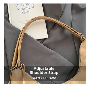 Close-up of adjustable strap and metal buckle on camel suede tote shoulder bag