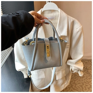 Detailed macro view of light blue crocodile embossed texture on a chic leather bucket bag